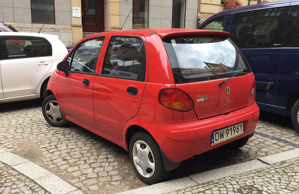 Petite voiture citadine garée en environnement urbain