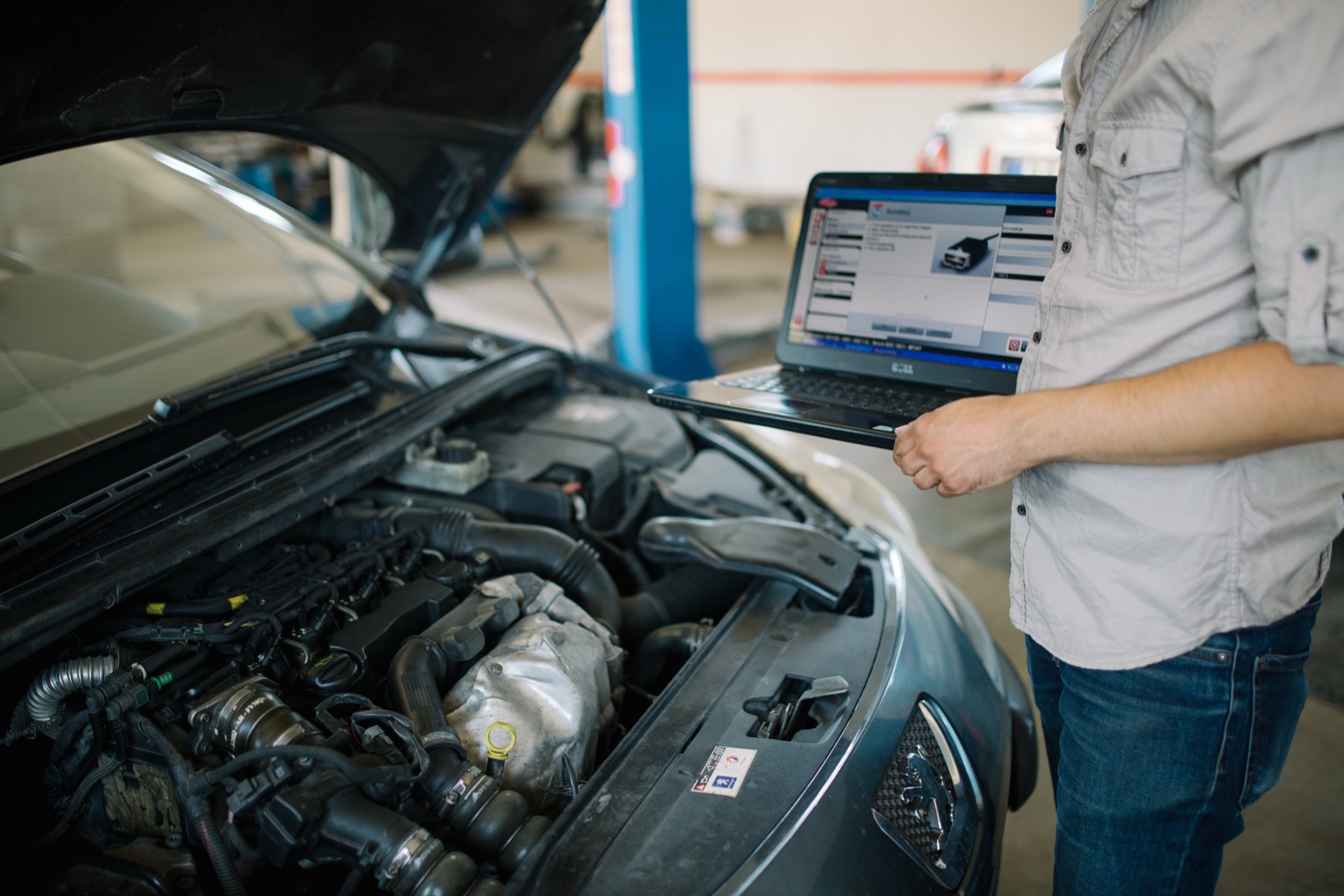 mécanicien qui fait un diagnostic électronique sur ordinateur portable dans un garage