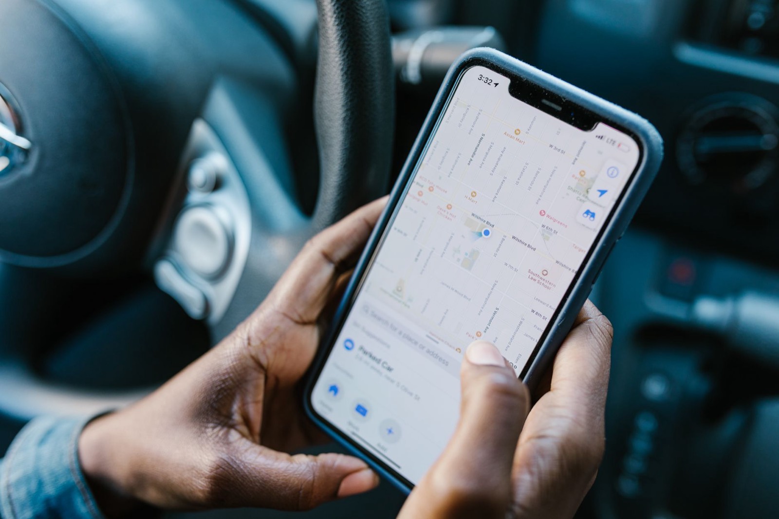 Un conducteur consulte une carte de garages sur son téléphone avant de prendre rendez-vous