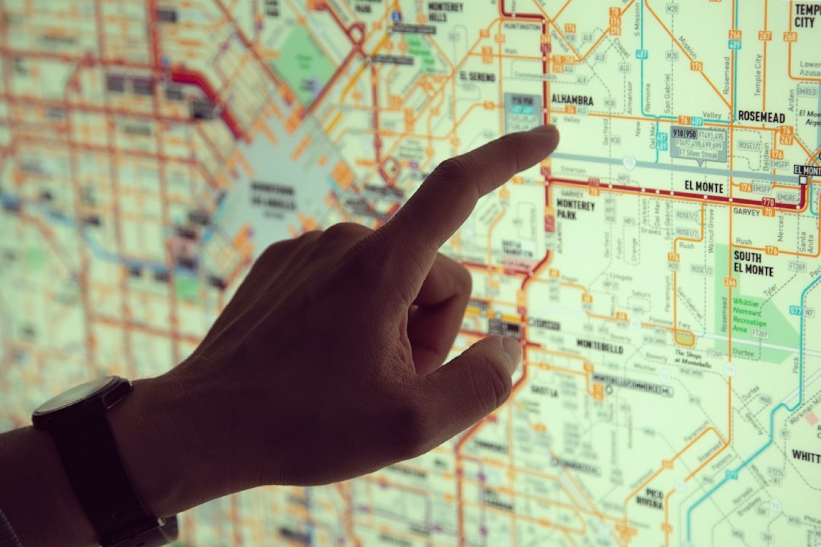 Main tenant un smartphone affichant une carte pour chercher un garage à proximité